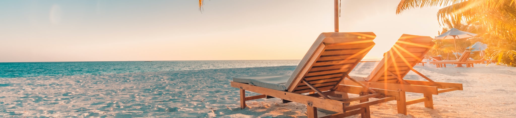 Strandliegen mit Schirm am Meer